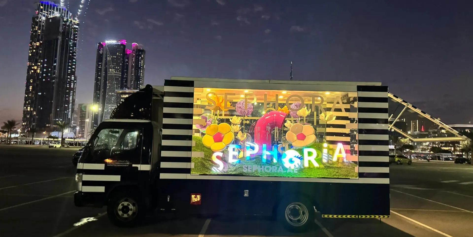 Side view of a glass activation truck with a festive display inside